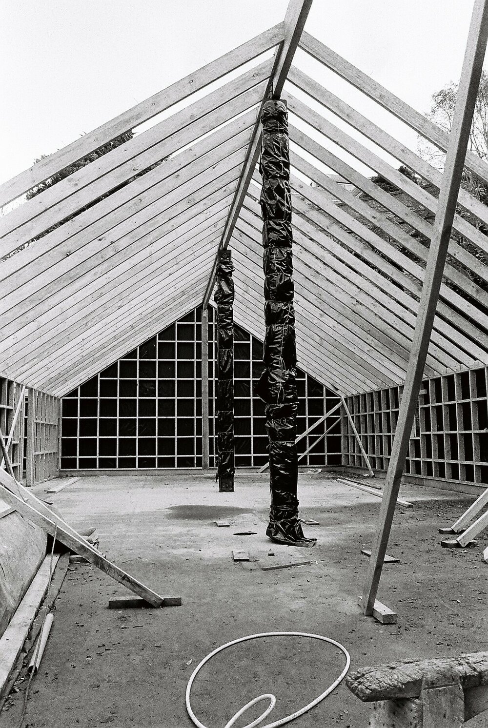 Front view of the wharenui under construction with poutokomanawa installed under protective cladding