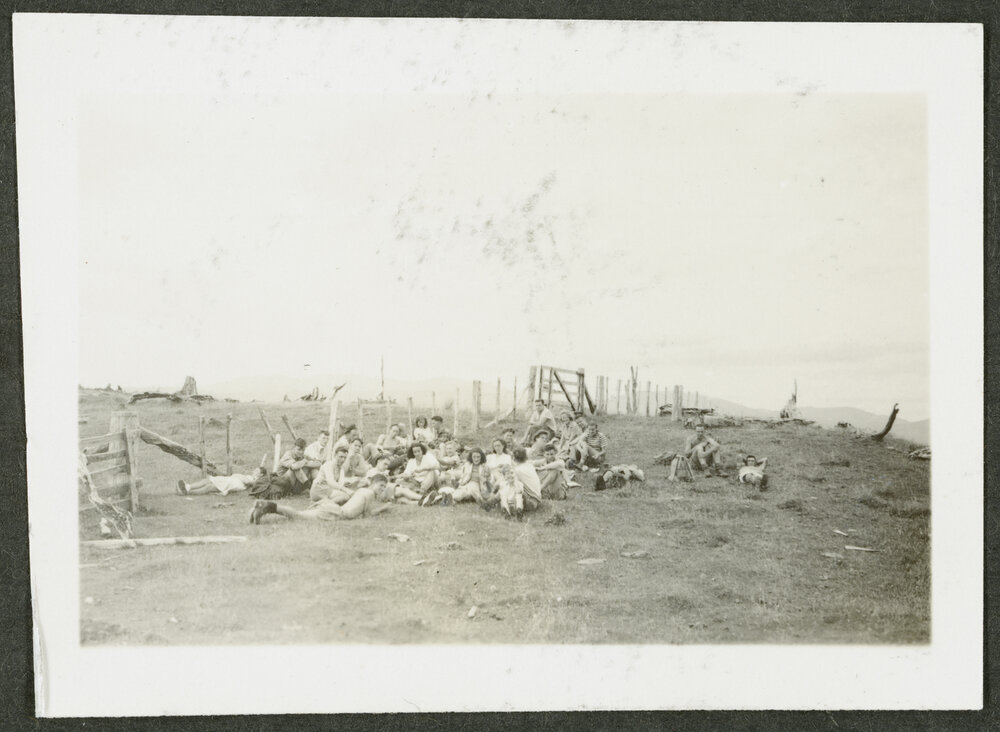[Image of a group of people sitting in a paddock.]