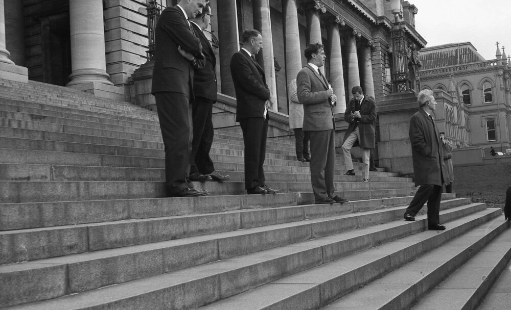 Group on Parliament steps address a protest group