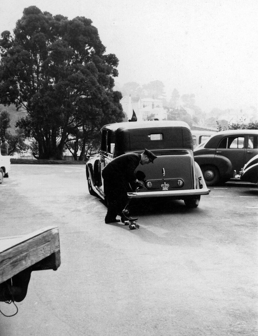 Governor General's chauffer removing tin cans attached to car