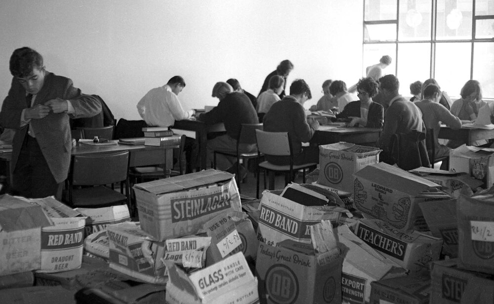 Students studying in new library surrounded by boxes of books