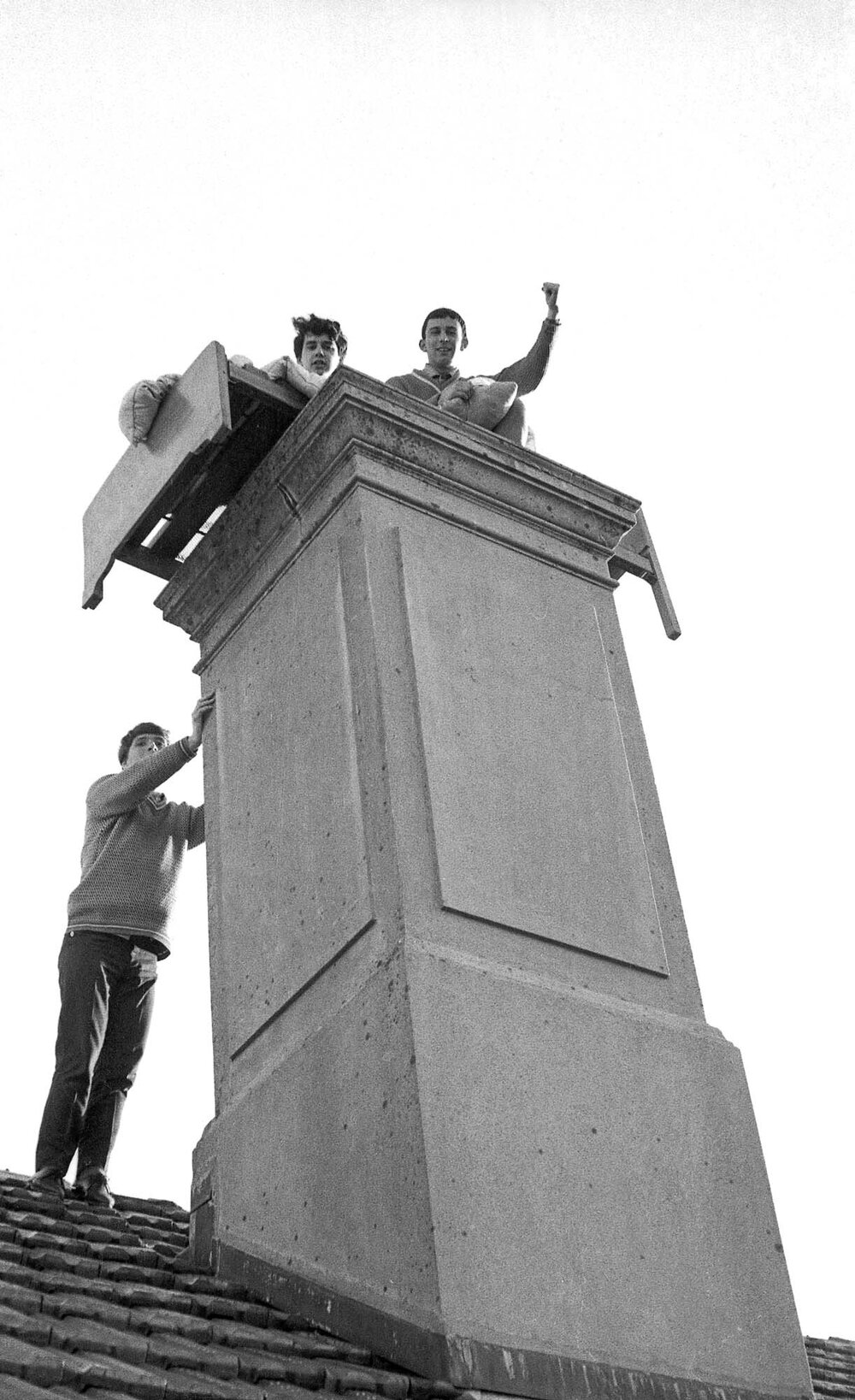 Students on the roof of Weir House, posing atop a chimney