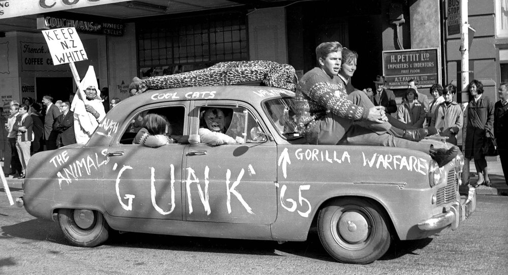 Students on top of Gunk '65 car at annual student procession through Wellington 