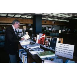 Slide 33 Person reading at new books display