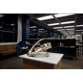 Slide 46 Sculpture on table, with student reading paper in background