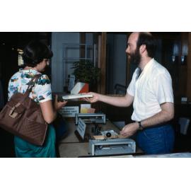 Slide 66 Library staff John Steers handing book to student