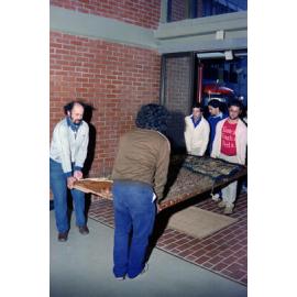 The carved poupou Taraika is carried into the Hugh Mackenzie building