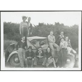 [Image of the tramping party sitting on a car.]