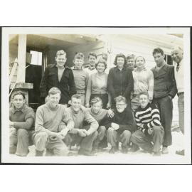 [Image of a group of people outside a hut.]