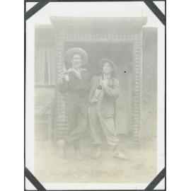 [Image of two men outside a house.]