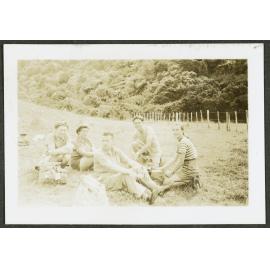 [Image of five people sitting in the grass.]