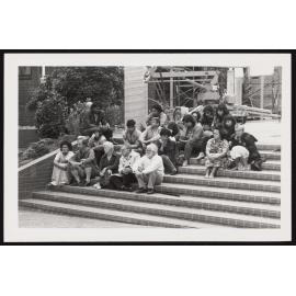 Tangata whenua of the welcoming party sit on the stairs