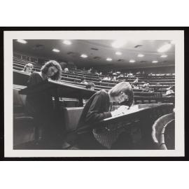 Students filling out forms in a lecture theatre (b)