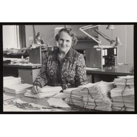 Mrs Pat McKay, Chief Exam Supervisor (1960-1980) sitting at a table filled with exam papers