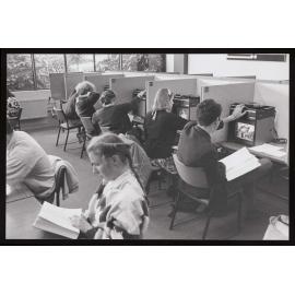 Students at desks using slide projectors