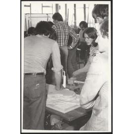 Student group creating architectural model from jigsawed wood pieces