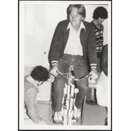 Student riding a stationary bicycle