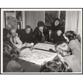 Group looking at architectural drawings around a table