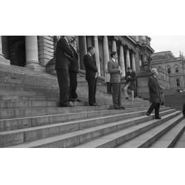 Group on Parliament steps address a protest group