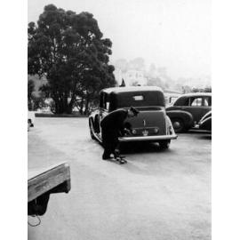 Governor General's chauffer removing tin cans attached to car