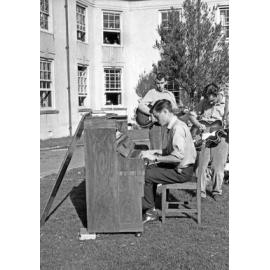 Weir House residents playing piano and guitar on the lawn