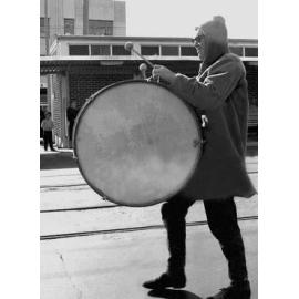 Student in costume playing a marching drum for the annual student procession